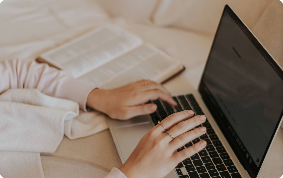 Working at a laptop beside an open notebook